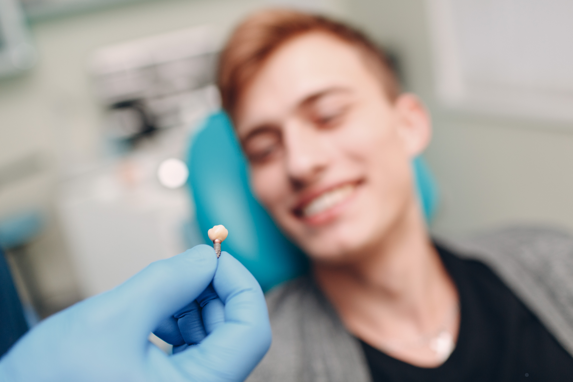 Dental implant held in hand, ready to be placed for a male patient, showcasing the precision and care involved in modern implant procedures.