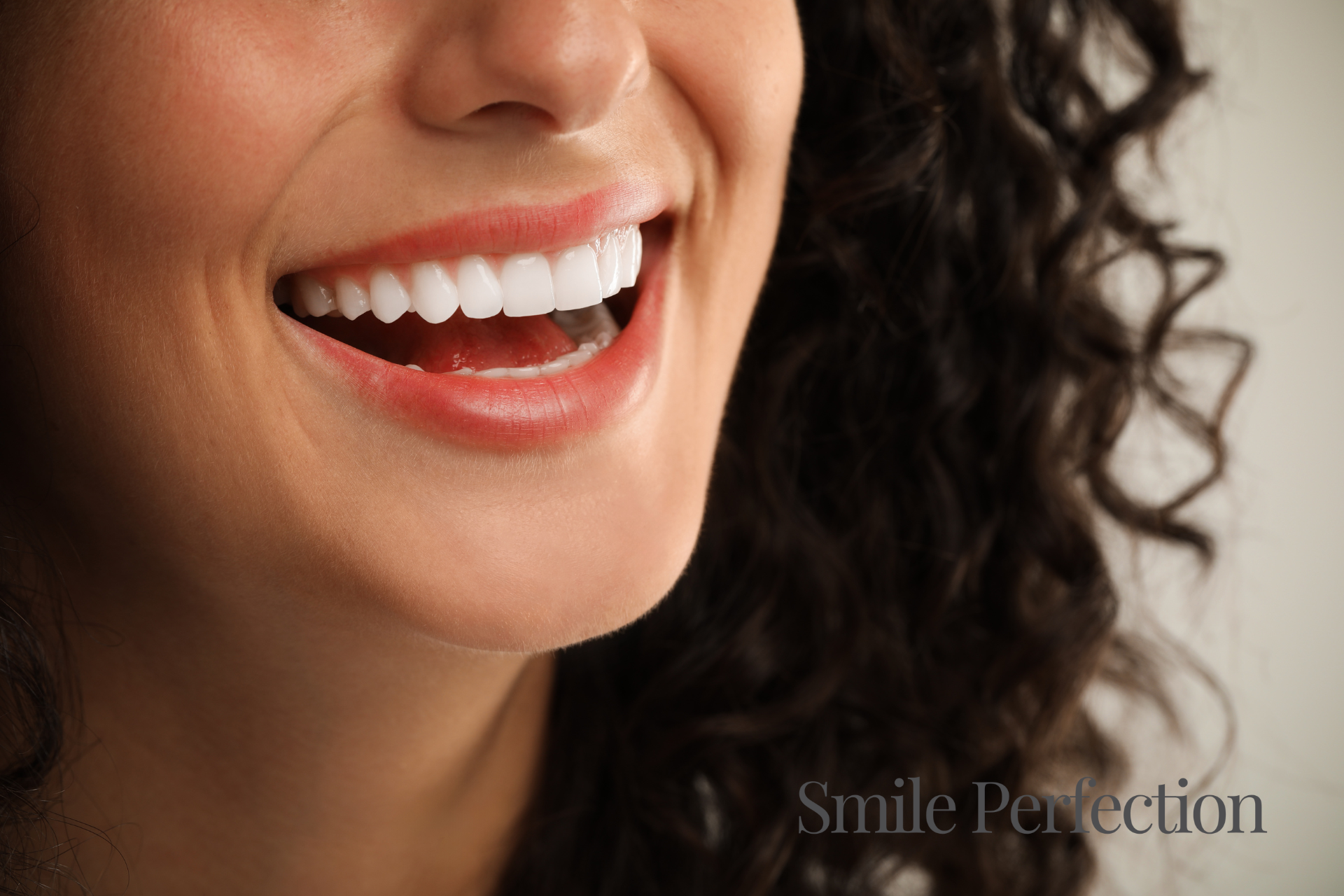 A woman showcasing a bright, flawless smile after receiving porcelain veneers, highlighting beautifully aligned and natural-looking teeth.